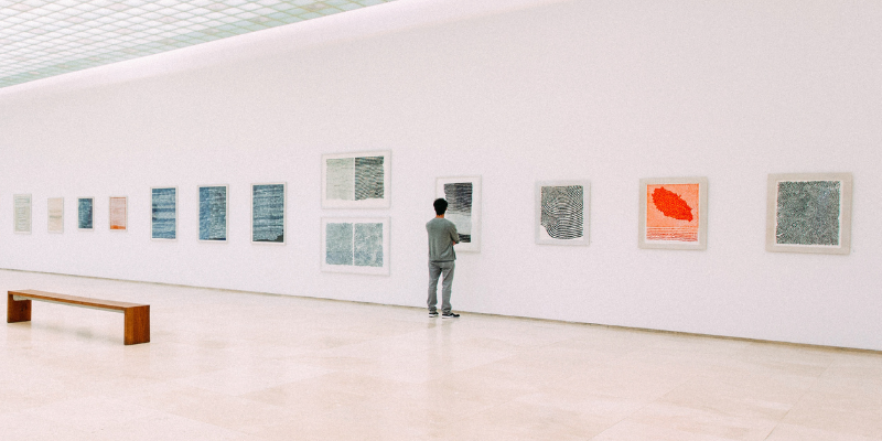 Un uomo guarda i quadri di una mostra in un museo