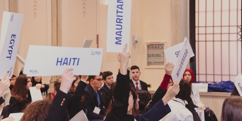 Ragazzi che tengono in mano dei cartoncini con nomi di paesi