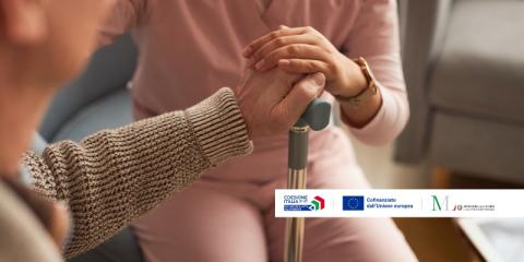 donna che tiene il bastone a un signore anziano